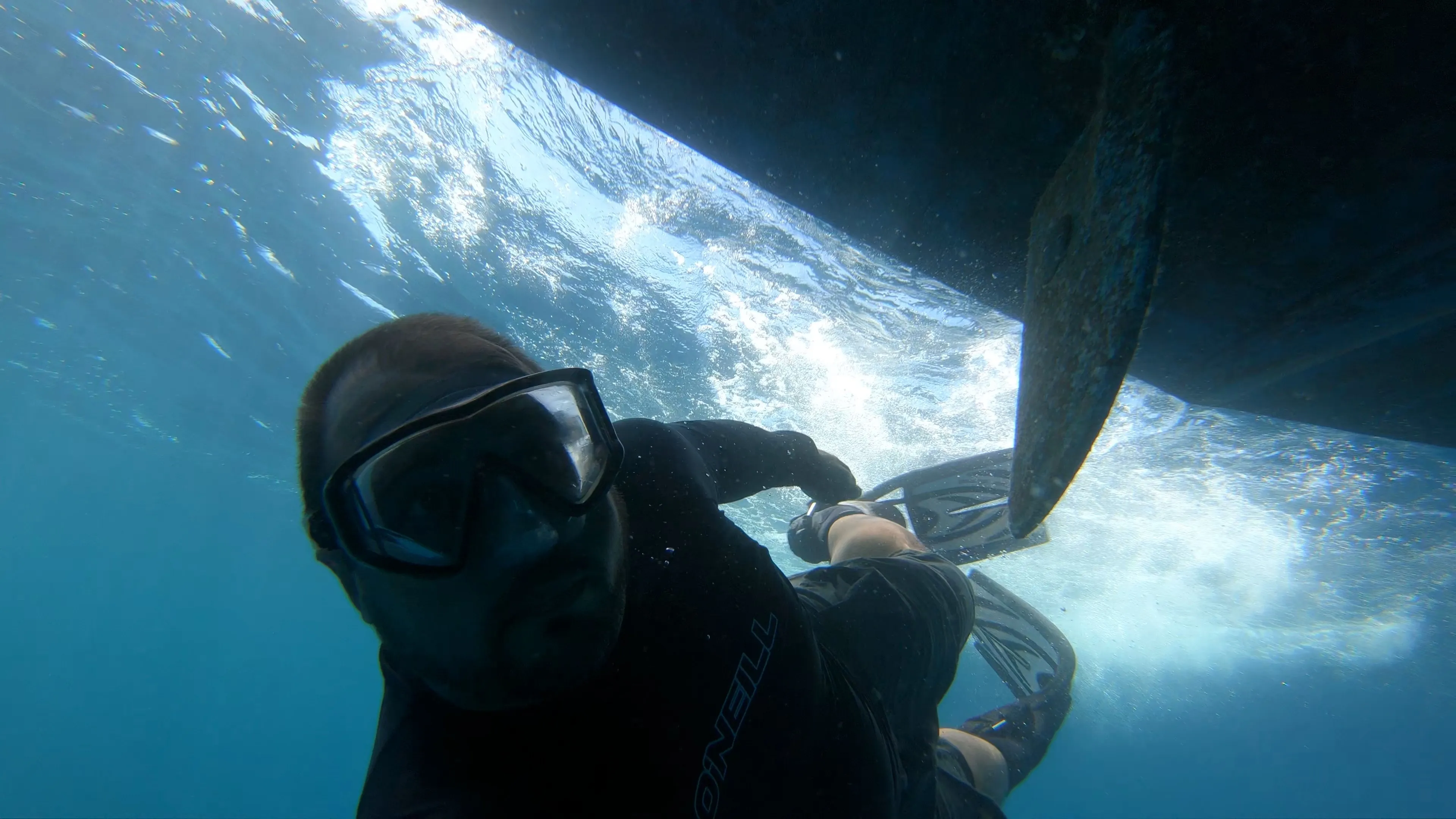 Dan Siegel freediving beneath a boat